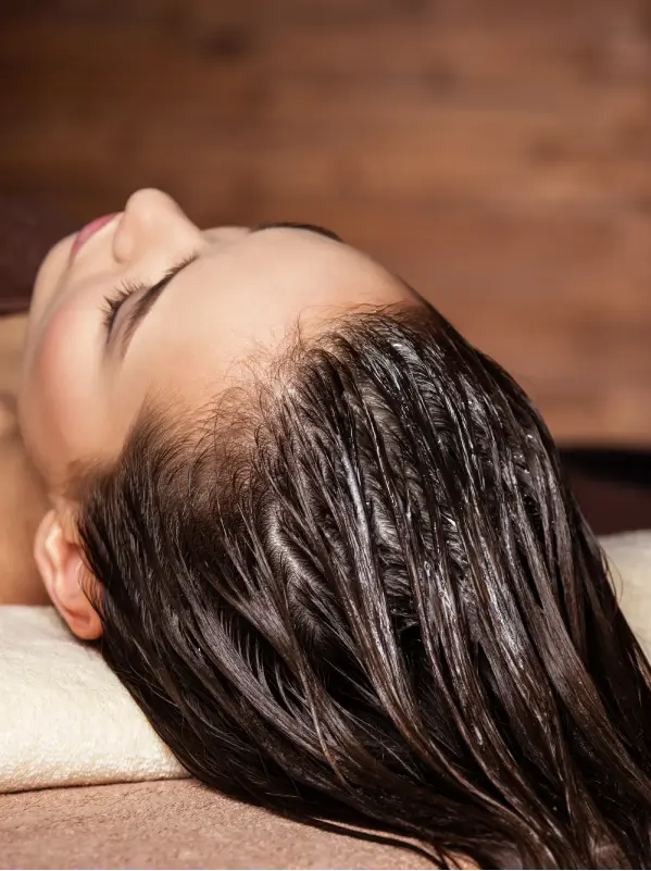 Woman receiving hair care procedure in spa salon